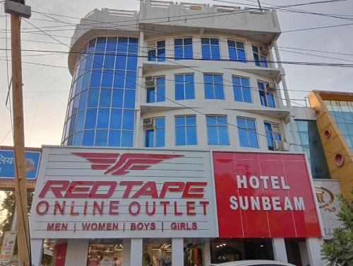 瓜廖尔Hotel Sun Beam Near Gwalior Railway Station的前面有标志的高楼