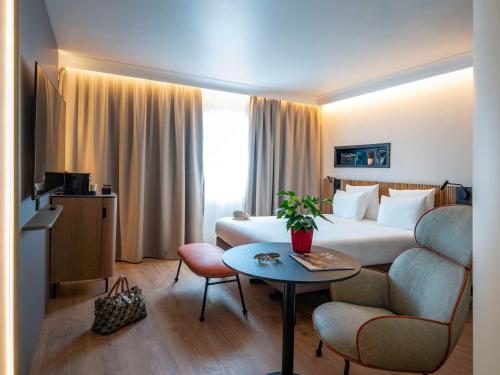 尼斯诺富特尼斯阿里纳斯阿罗伯特酒店的酒店客房配有一张床铺和一张桌子。