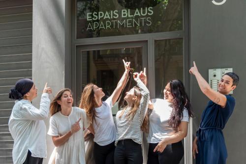 巴塞罗那伊斯帕布劳思公寓的一群站在建筑物外的女人,手放在空中
