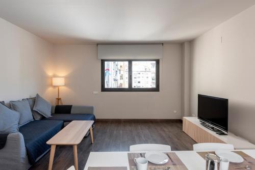 巴塞罗那伊斯帕布劳思公寓的客厅配有蓝色的沙发和电视