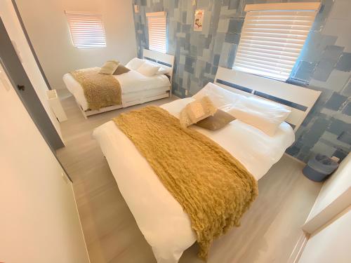 IchigayaLOOP HOTEL OCEANS with Etenity 千葉一宮的一间卧室设有两张床和两个窗户。