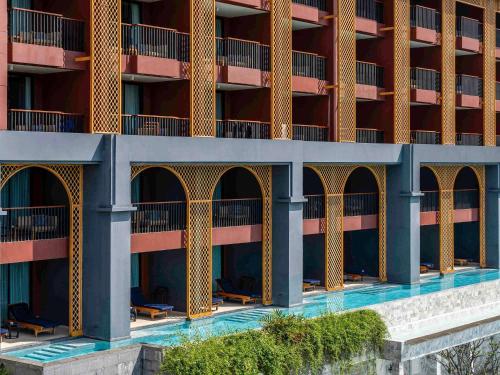 卡伦海滩Avista Grande Phuket Karon - MGallery的一座带游泳池的公寓大楼的图片