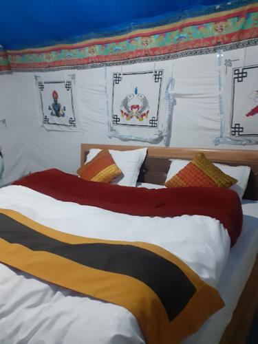 ChimreMartsemik Camping Spangmik的床上配有色彩缤纷的毯子和枕头