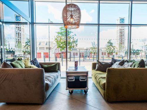 朗斯ibis Styles Lens Centre Gare的客厅配有两张沙发和一张桌子