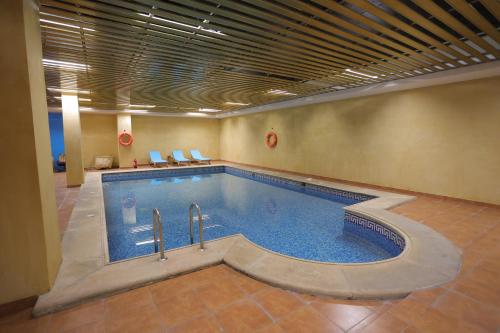 利雅德Dar Hashim Hotel Suites - Alnuzha的一座带游泳池的大楼内的大型游泳池