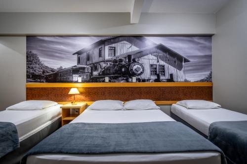 CaçadorBrivali Hotel e Eventos的一张带房子绘画的房间的两张床