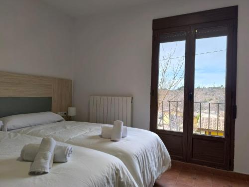 鲁比罗德莫拉Masia Del Cura的一间卧室设有两张床和一个美景窗户。