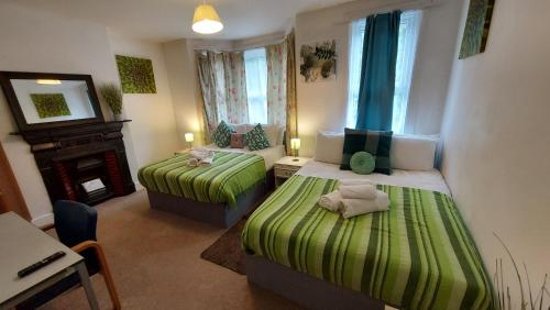 查塔姆Cosy Villa- 5 Bedroom Accommodation Great For Longer Stays!!!的小房间设有两张床和壁炉