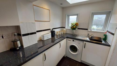 查塔姆Cosy Villa- 5 Bedroom Accommodation Great For Longer Stays!!!的厨房配有水槽和洗衣机
