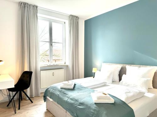 格尔斯托芬E&K living - city central - design apartment - kitchen - free parking的一间卧室配有一张床、一张书桌和一个窗户。