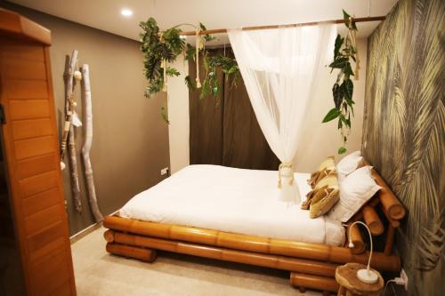 列日L'appart Baobab, avec sauna的一间卧室配有一张带蚊帐的床