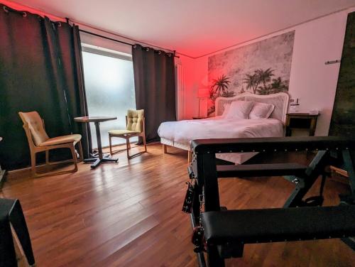 巴黎Jacuzzi LOVE appartement的卧室配有一张床和一张桌子及椅子