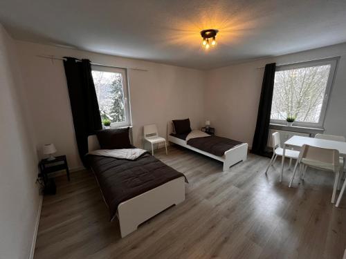 埃内佩塔尔Tolle Monteursunterkunft für 6 Personen的一间卧室设有两张床、一张桌子和窗户。