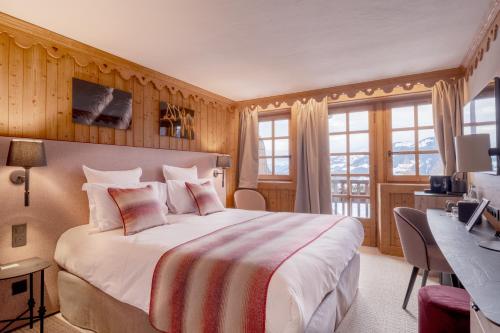 梅杰夫La Ferme du Golf的酒店客房设有一张大床和一张书桌。