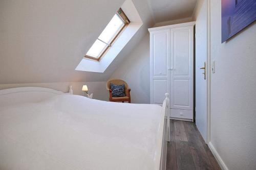 博尔滕哈根Ferienwohnung Papillon Boltenhagen的卧室配有白色的床和天窗