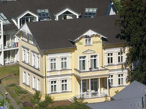 奥斯特巴德·哥伦Villa Granitz - Ferienwohnung 45466 (Sassnitz)的黑色屋顶的黄色房子