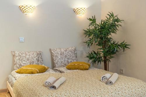 维尔纽斯Cozy Suite Roomita的一间卧室配有带枕头和植物的床