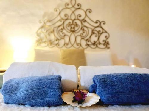RasqueraCasa de Danann的床上有两条蓝色的毛巾和一朵花
