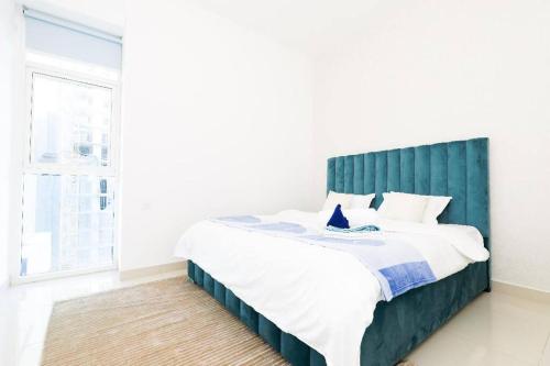 迪拜1BR Luxury Apartment close to JBR Beach Marina的一间卧室配有一张大床和绿色床头板