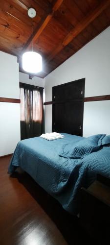 里奥格兰德HOSPEDAJE EL GRINGO - CASA ALOJAMIENTO COMPLETO的一间卧室配有一张带蓝色棉被的床
