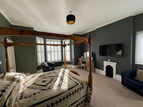 伯恩茅斯Hotel 50的一间卧室设有一张天蓬床和一个壁炉