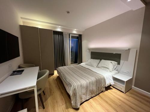 巴统NG Apartments On First Line的酒店客房配有一张床、一张书桌和一张书桌。
