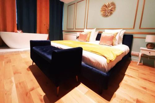 巴黎ROYAL SUITE PARIS REPUBLIQUE的卧室配有1张床、浴缸和椅子