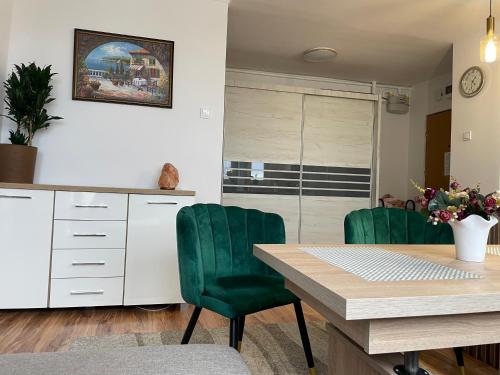蒂黑Apartament Żwakowska的厨房配有桌子和两把绿色椅子