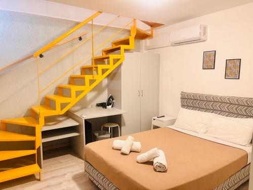 雅典埃尔维塔公寓 的一间卧室设有一张床和黄色的楼梯