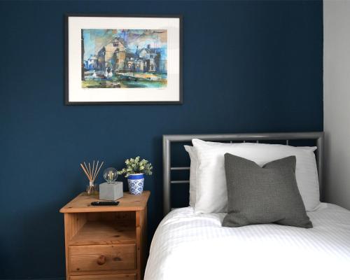 拉夫堡Hermitage, 3 Bed entire House in Loughborough的一间拥有蓝色墙壁的卧室、一张床和床头柜