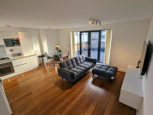 伦敦NEW Lux 1 or 2 Bed Flats + Car Park + 5min Tube + Fast WiFi的客厅配有沙发、椅子和桌子