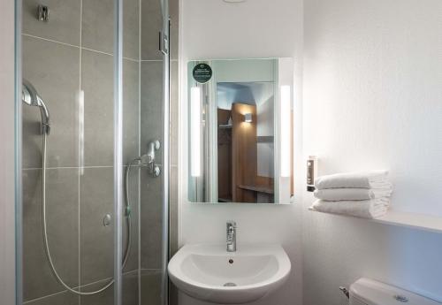 勒藏讷B&B HOTEL Lille Lezennes Stade Pierre Mauroy的浴室配有盥洗盆和带镜子的淋浴