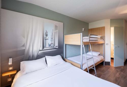 勒藏讷B&B HOTEL Lille Lezennes Stade Pierre Mauroy的一间卧室配有一张床和一张双层床。