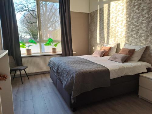 阿尔滕B&B de Wilhelminaschool的一间卧室设有一张大床和一个窗户。