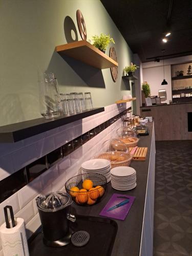 阿尔滕B&B de Wilhelminaschool的厨房里有一个盘子和橙子的柜台