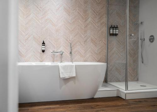 法尔肯堡法尔肯堡汉普郡酒店的设有带浴缸和淋浴的浴室。