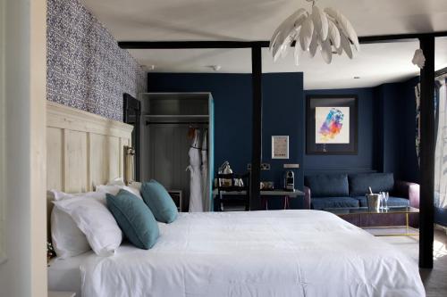 滕特登白狮宾馆的卧室配有白色大床和蓝色的墙壁