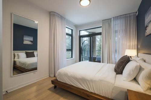 蒙特朗布朗Verbier 1-103 / Vast & Luxurious 3 bedroom的一间卧室配有一张大床和镜子