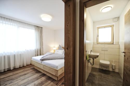 佩尔蒂绍洛森霍夫公寓的一间卧室配有床、水槽和卫生间