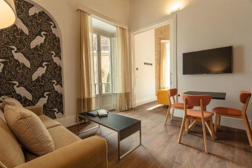 格拉纳达Casa Miravalle Catedral的客厅配有沙发和桌子