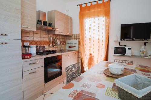 贡内萨Sardinia's house IUN R5500的厨房配有桌子和碗
