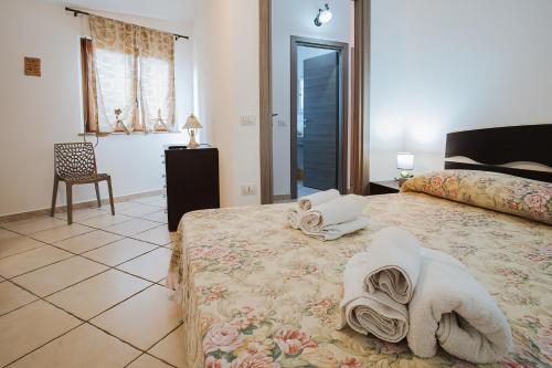 贡内萨Sardinia's house IUN R5500的一间卧室配有带毛巾的床