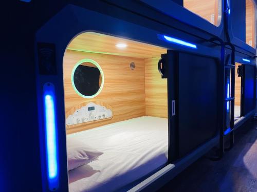 纽约KAMA CENTRAL PARK的一间小卧室,卧室内配有一张床铺,房间拥有蓝色的灯光