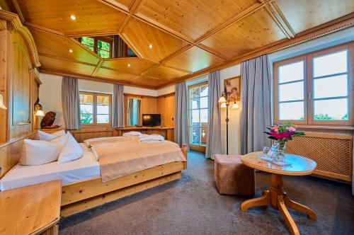 罗森海姆Hotel Happinger Hof的一间卧室设有一张带木制天花板的大床