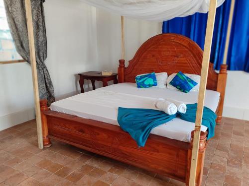 南威EAST SANDBANK apartment eco-friendly Nungwi airport road的一间卧室配有一张带毛巾的天蓬床。