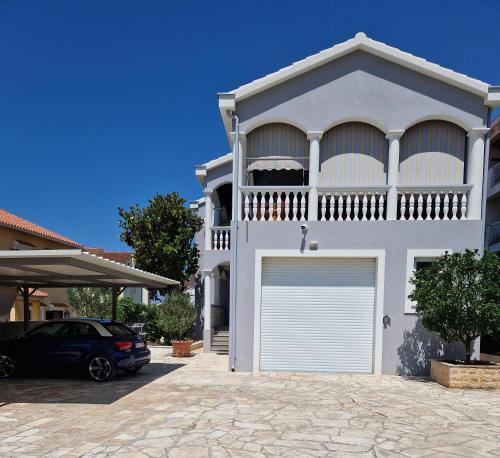 扎达尔Cosy villa near the beach的前面有一辆汽车停放的白色房子