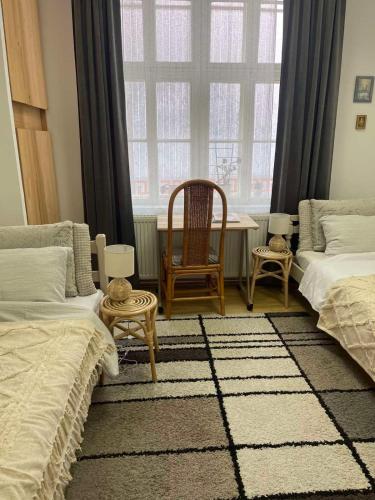 温科夫齐Lennon的一间卧室设有两张床、一张桌子和一个窗口