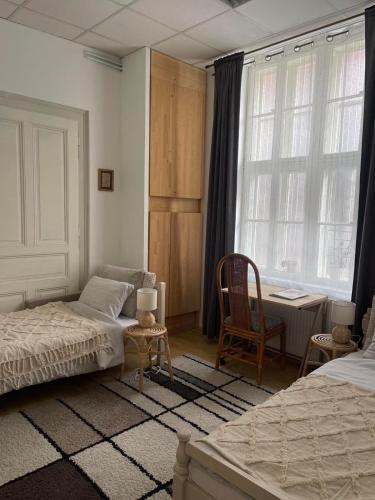 温科夫齐Lennon的一间卧室配有两张床、一张桌子和一把椅子