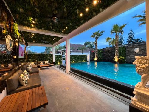 乔木提恩海滩NEW 2022 Grand Deluxe ART Pool Villa的一个带游泳池和庭院的户外客厅