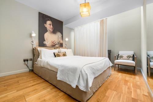 卡迪夫Sophia Gardens Apartment的卧室配有一张床和一张男子肖像